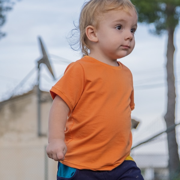 Niño con camiseta naranja de algodón orgánico