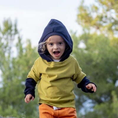 Boy dressed in green and navy blue layered effect sweatshirt.