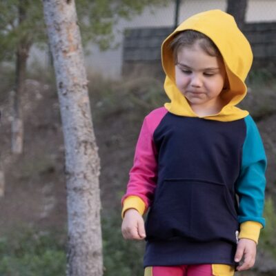 Niña vistiendo la sudadera en 4 colores (Azul marino, petróleo, rosa fucsia y amarillo) Kuivi de ToTó